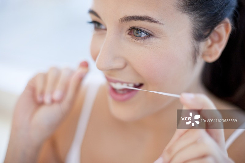 女人用牙线清洁牙齿图片素材