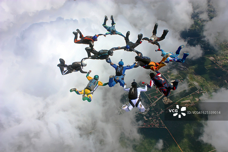 跳伞运动员在云层上方编队图片素材