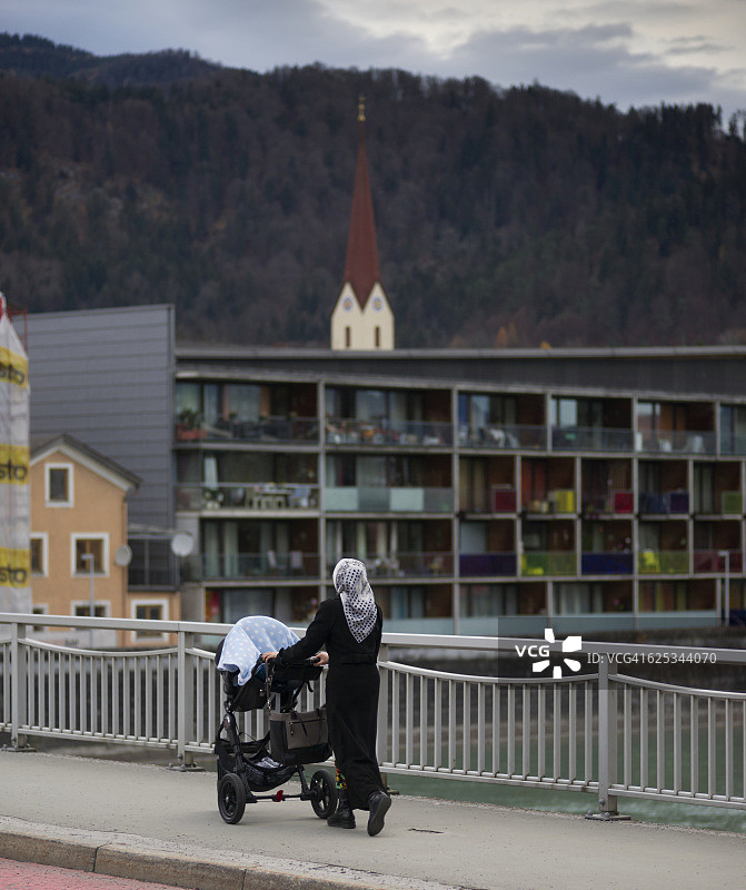 奥地利蒂罗尔州库夫施泰因：戴头巾的妇女推着婴儿车图片素材