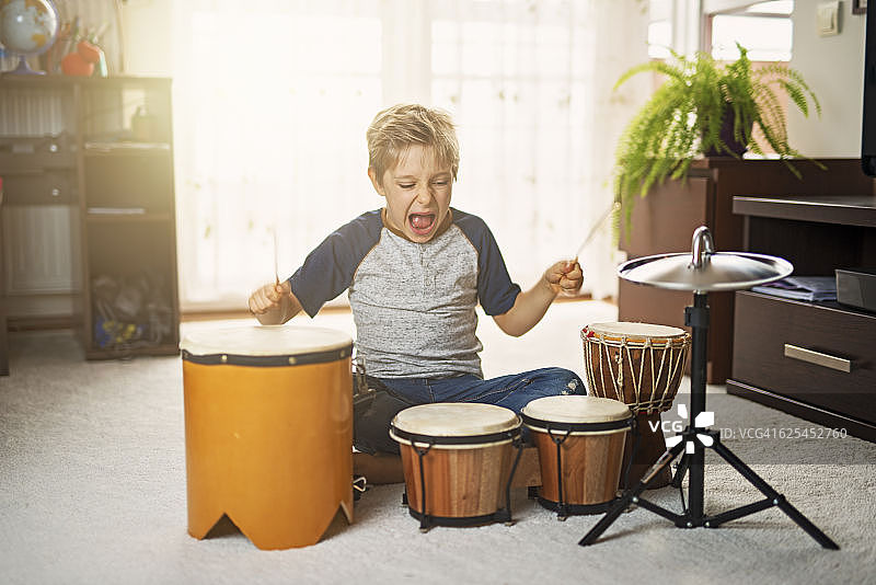 小男孩在临时鼓上敲打图片素材