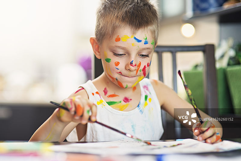 可爱的小男孩用双手绘画图片素材