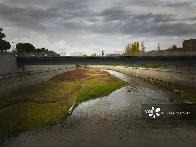 一个孤独的男人走在西班牙马德里河上的桥上图片素材