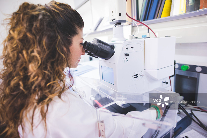 女科学家使用FTIR分光光度计，通过FTIR显微镜观察薄膜样品图片素材