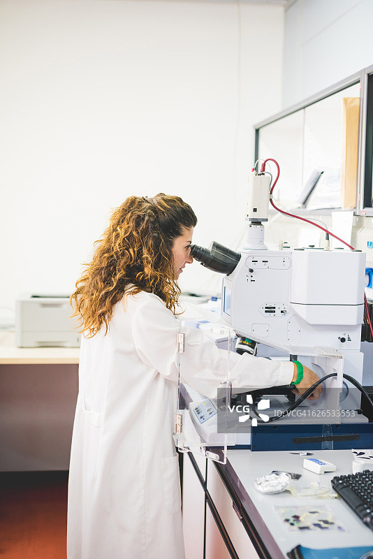 女科学家使用FTIR分光光度计，通过FTIR显微镜观察薄膜样品图片素材