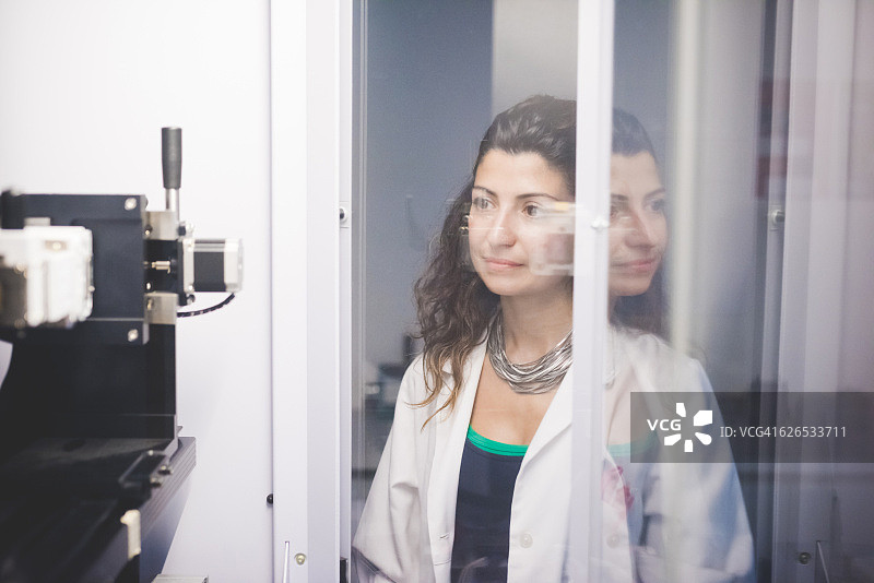 在X射线衍射仪上监测电机对准情况的女人图片素材