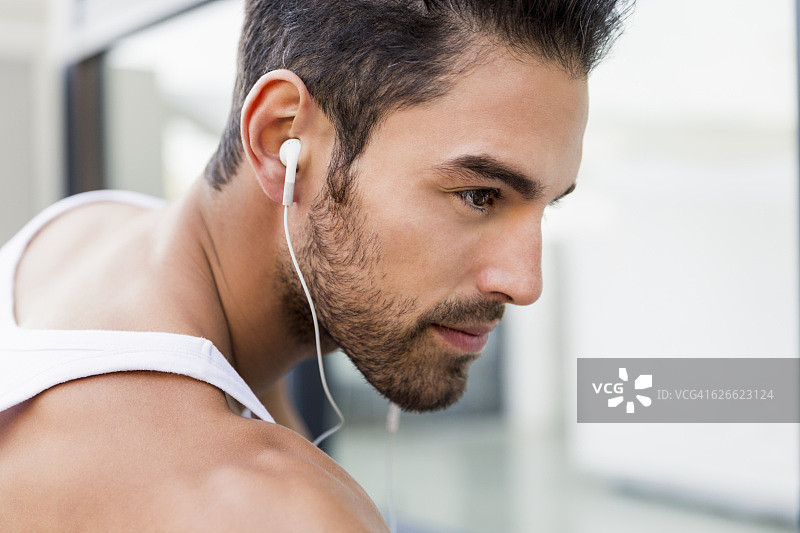 戴着耳机听音乐的运动型男人图片素材