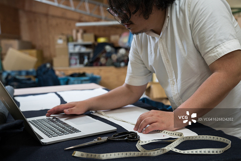 时装设计师在工作室使用电脑工作图片素材