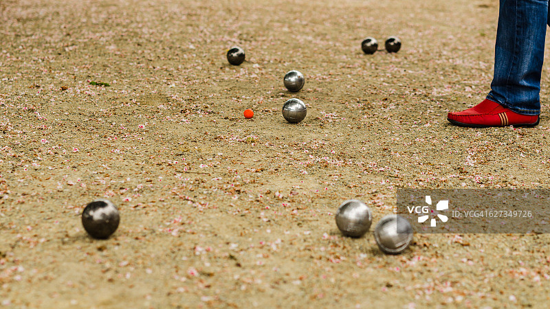 男人在比赛中判断哪个球更靠近目标图片素材