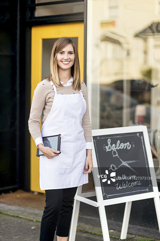 年轻女沙龙店主站在店外图片素材