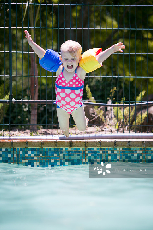快乐的女婴跳入泳池图片素材