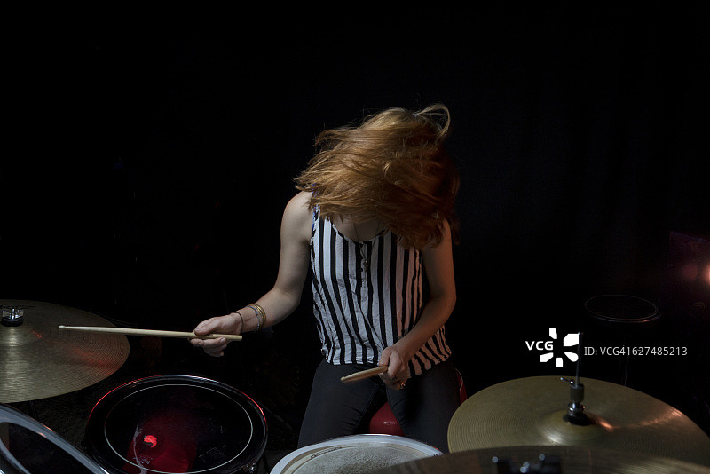 专注打鼓的年轻女人图片素材