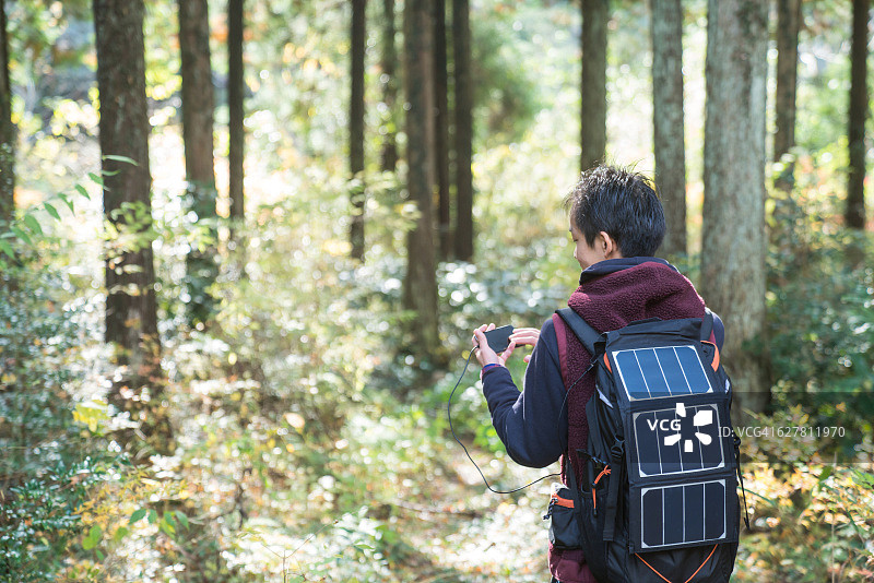 在森林中使用太阳能GPS的男人图片素材