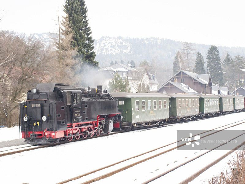 雪景中蒸汽机车牵引的小型客运列车图片素材