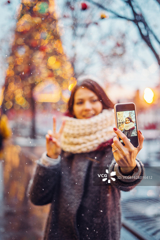 女人在圣诞树前自拍图片素材