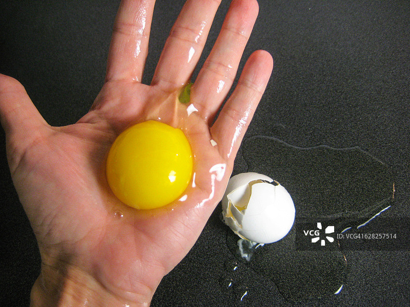 手掌中破裂的生鸡蛋图片素材