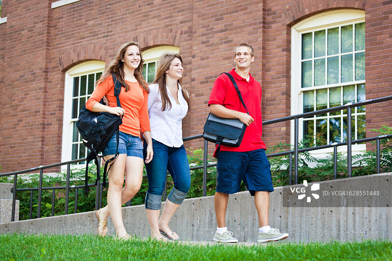 学生走在大学校园宿舍旁图片素材