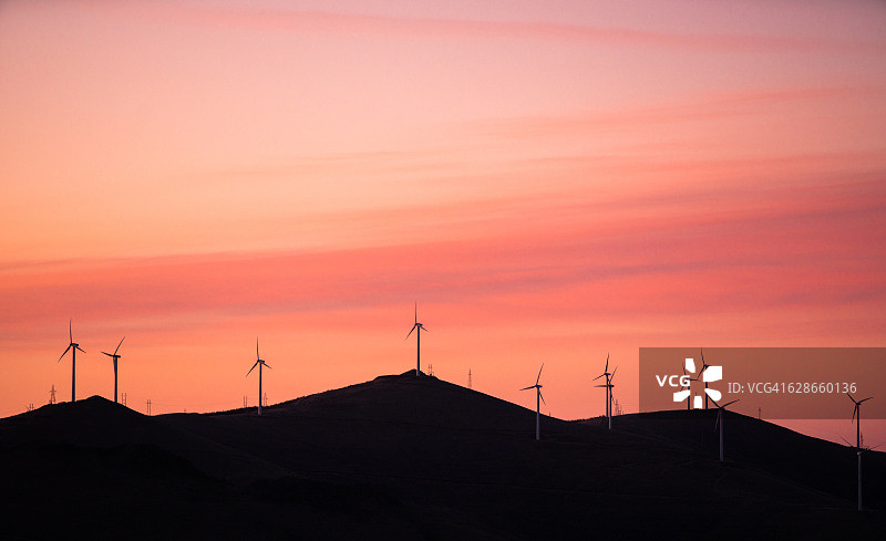 红橙日落下的风力发电机图片素材