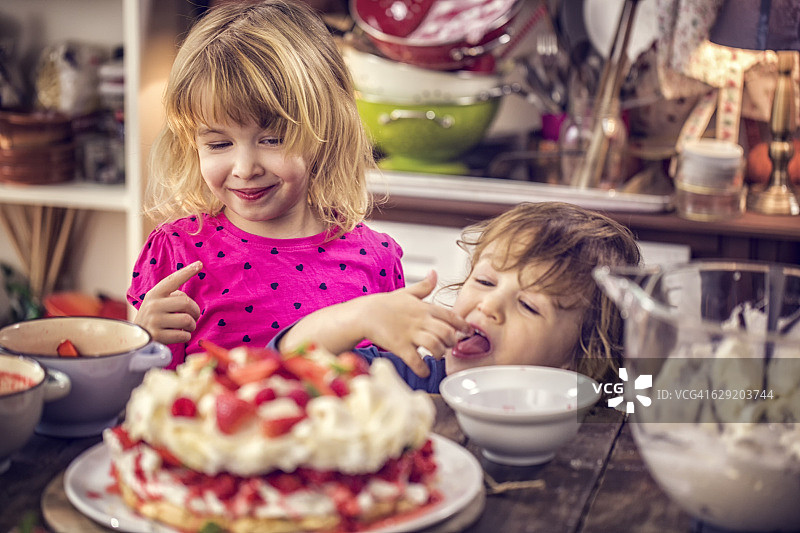 孩子们吃浆果巴甫洛娃蛋糕，配草莓和覆盆子图片素材