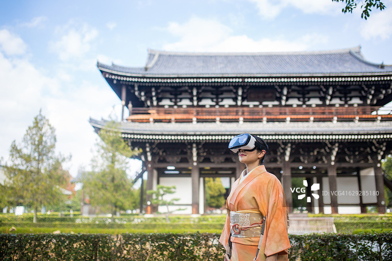 佩戴VR头显的女子，背景为日本风光图片素材