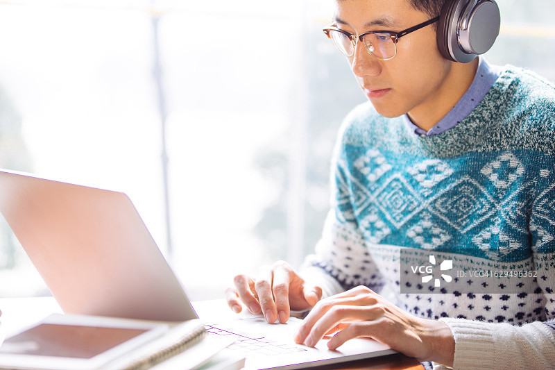 使用笔记本电脑的亚洲男学生图片素材