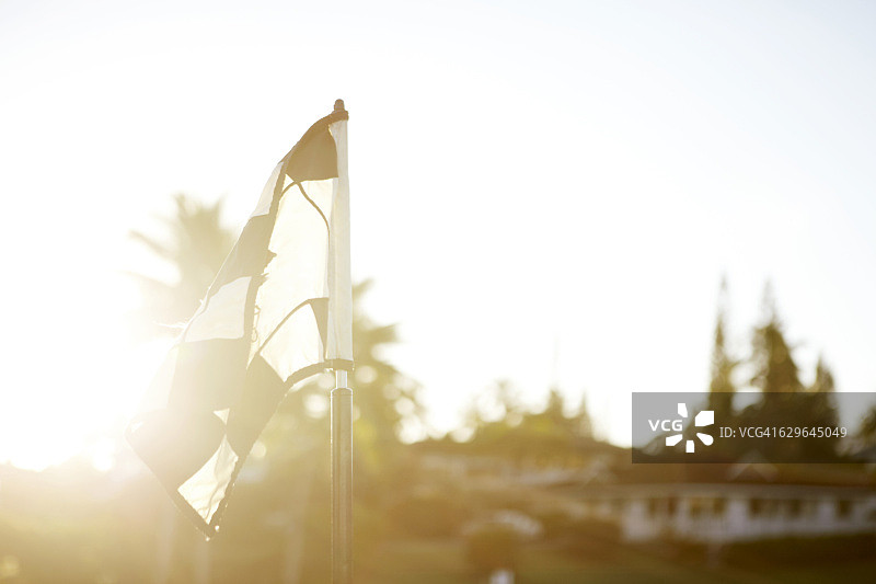 阳光照射下的高尔夫球场旗帜图片素材