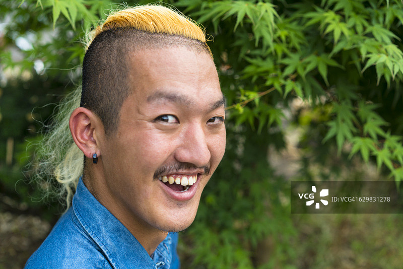 面带微笑、留着易洛魁发型的男人肖像图片素材