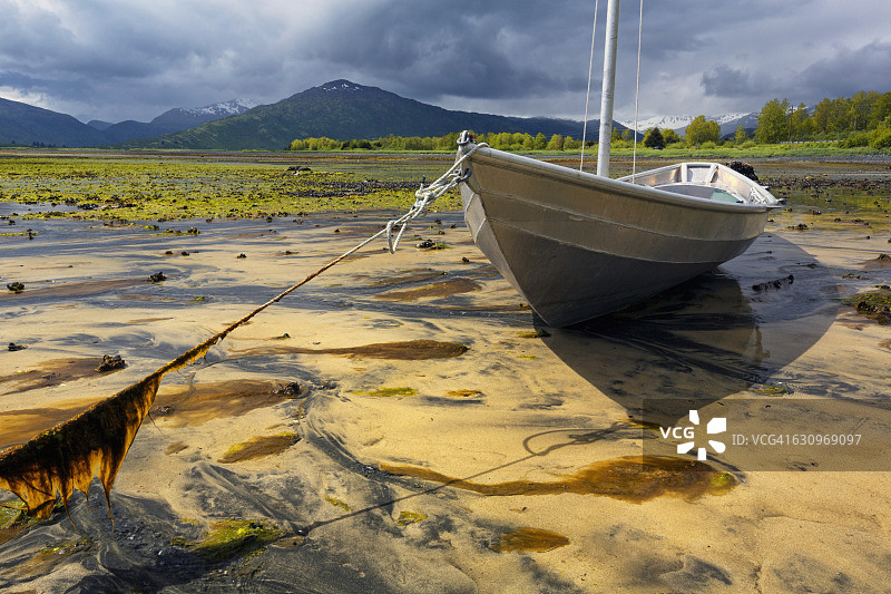 科迪亚克岛女子湾低潮时沙滩上的铝制小船，阿拉斯加图片素材