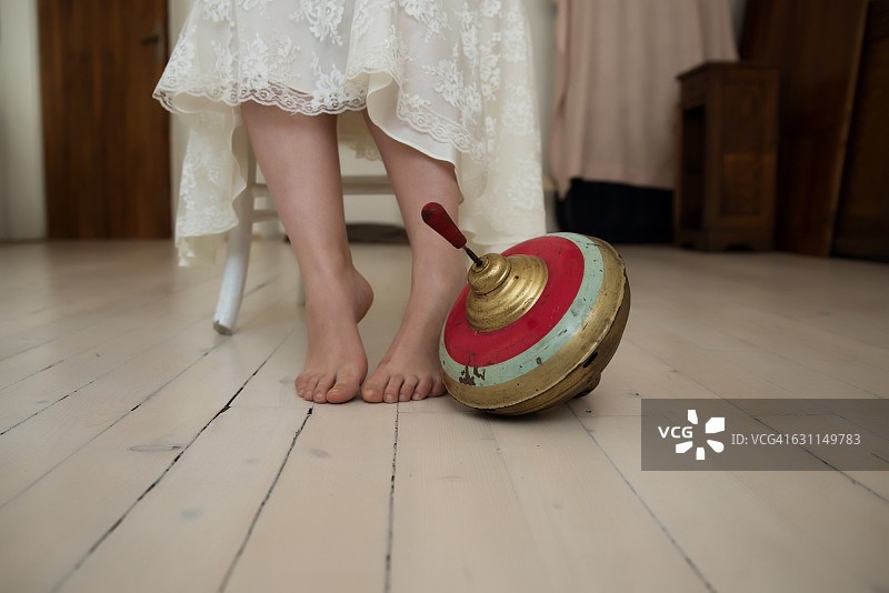 女孩脚边的老式陀螺图片素材