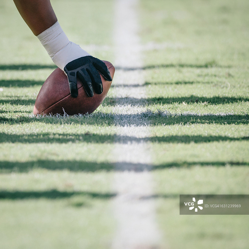 手放在球上的足球运动员图片素材