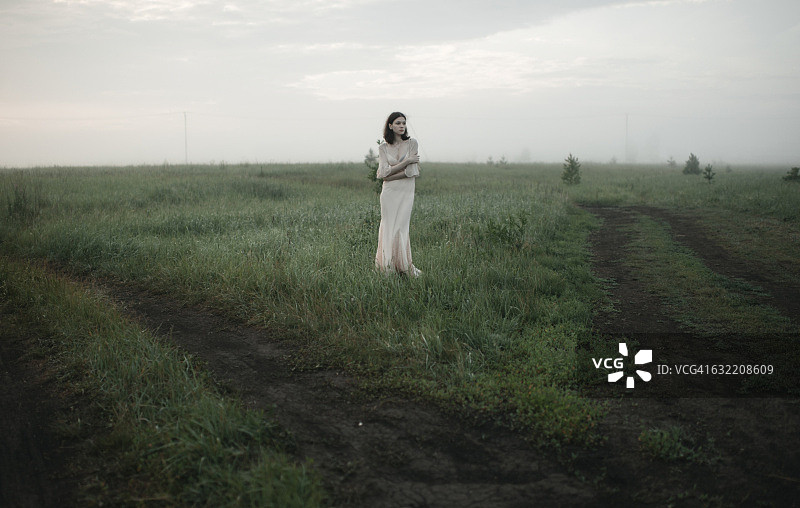 站在偏远田野里的白人女性图片素材