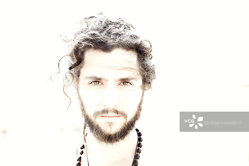 有胡子和卷发的年轻男人肖像图片素材