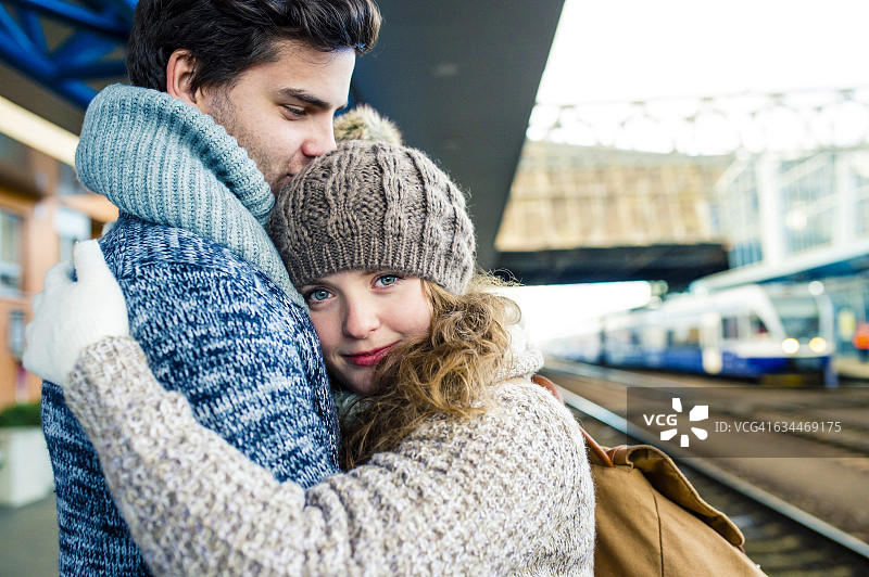 车站站台上拥抱的年轻夫妇图片素材