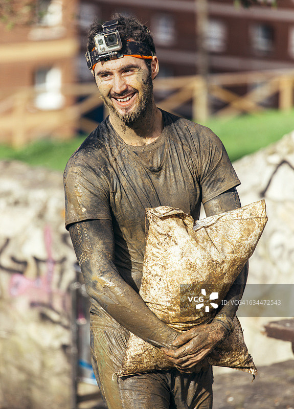 参加极限障碍赛的选手扛着沙袋图片素材