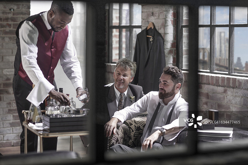 新郎与伴郎和侍者在酒店房间图片素材