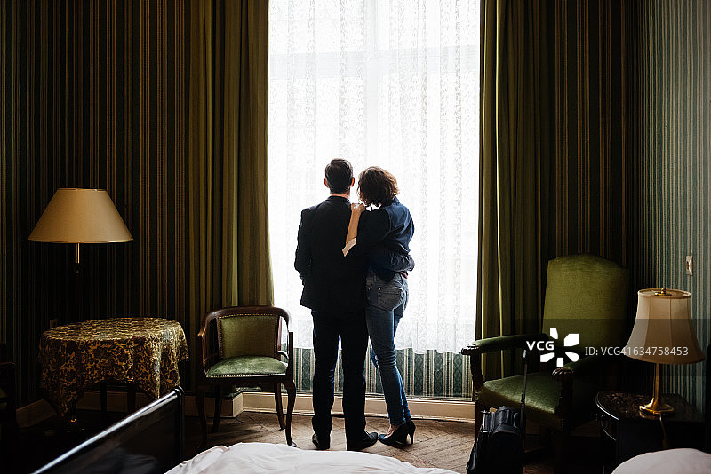 一对中年夫妇站在明亮的窗户前图片素材