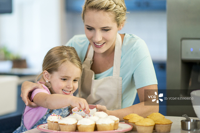 在纸杯蛋糕上撒糖屑图片素材