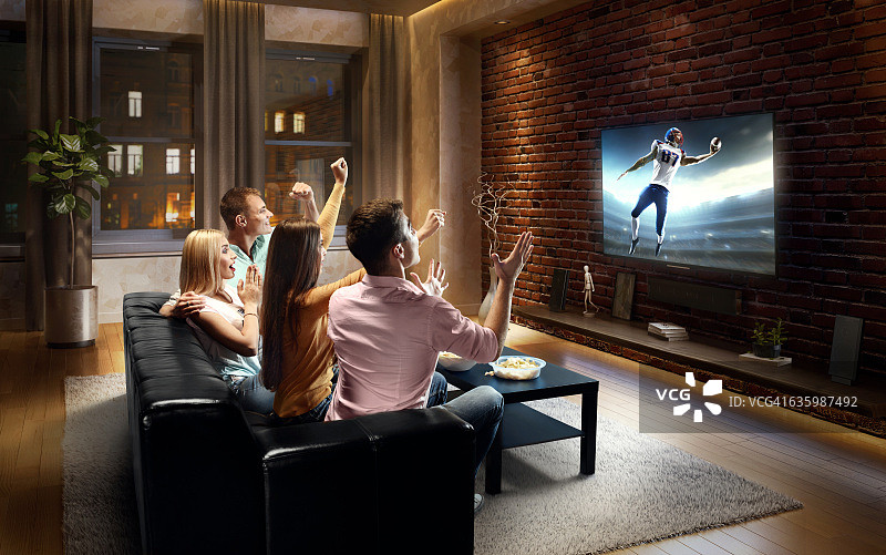 情侣在家观看美式足球比赛图片素材