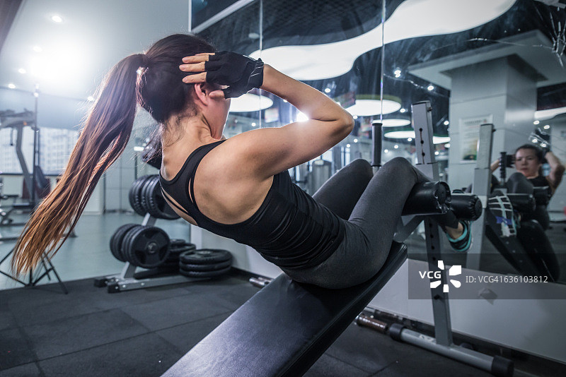 在现代健身房锻炼的年轻漂亮女性图片素材