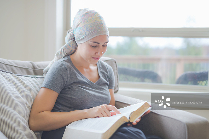 正在阅读圣经的少数民族成年女癌症患者图片素材