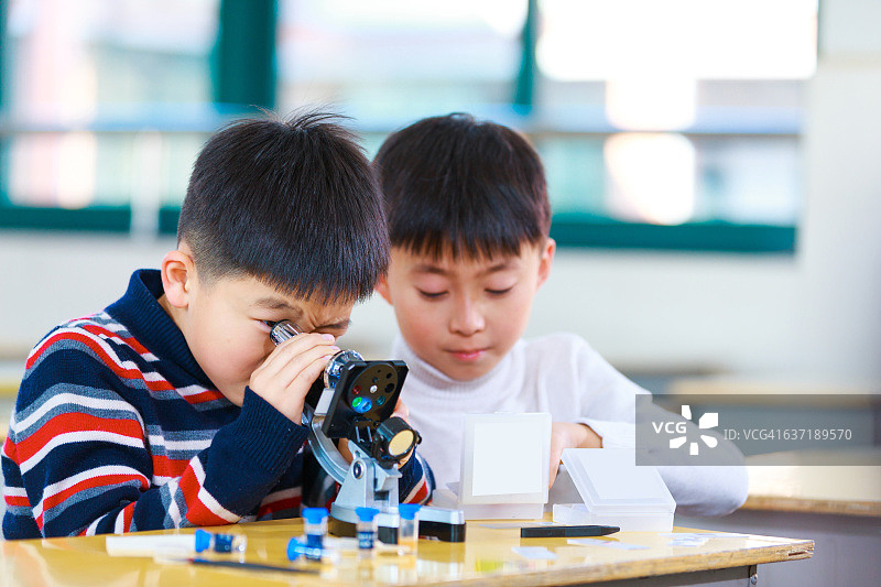 亚洲小学生在教室里讨论实验图片素材