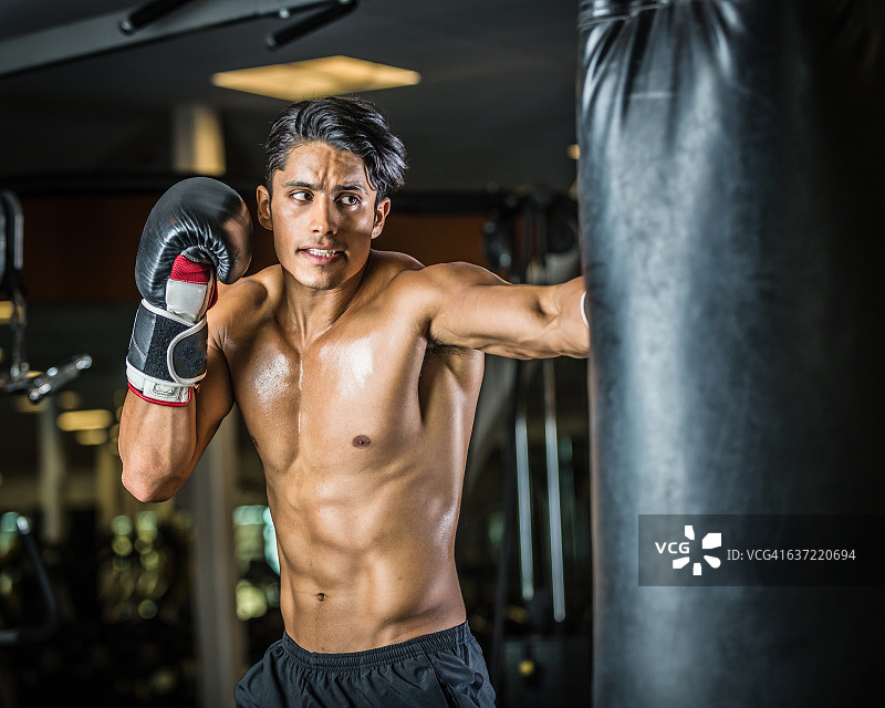 击打沙袋的西班牙裔男人图片素材