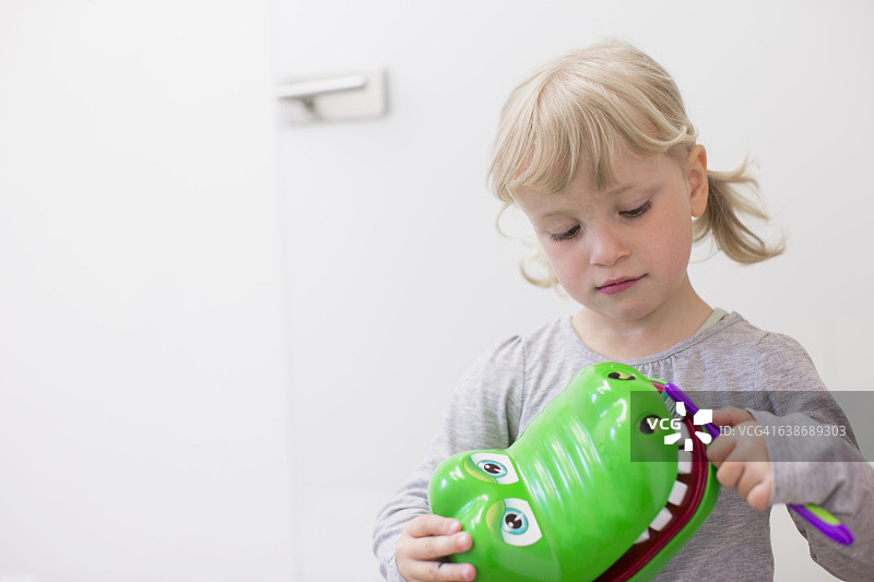 女孩刷玩具鳄鱼牙齿图片素材