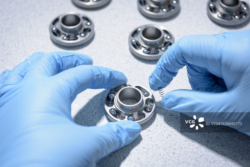 汽车零部件工厂装配线上工人组装阀门旋转器的特写图片素材