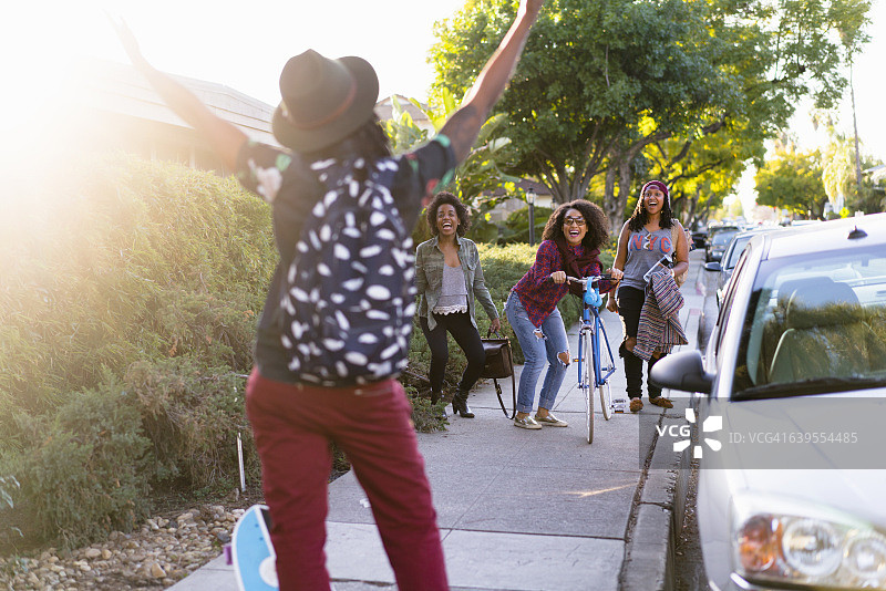 女人在街上向朋友做手势（后视图）图片素材