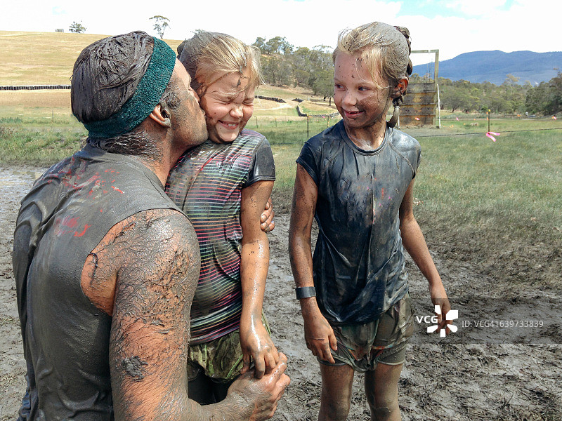 泥泞中父亲亲吻女儿图片素材