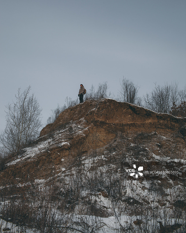 冬季登山者站在山顶的仰视视角图片素材