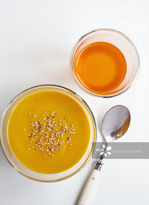 白色背景下的胡萝卜泥和饮料俯视图，配有勺子图片素材