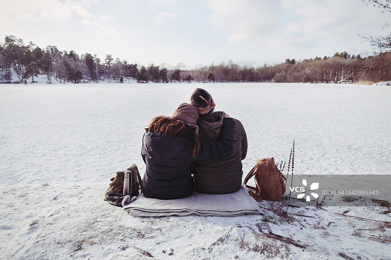 徒步旅行者坐在雪地上的背面图片素材