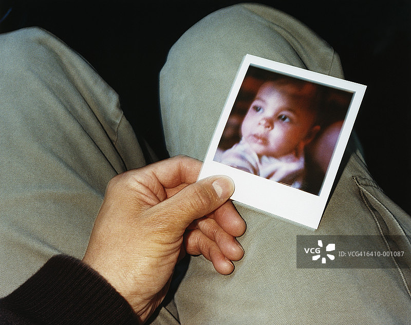 拿着婴儿照片的男人图片素材