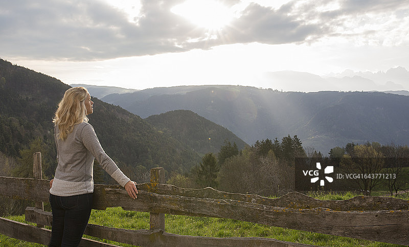 女人从乡村栅栏眺望山景图片素材